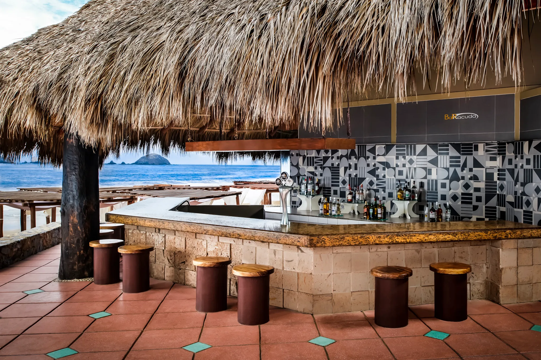 Barracuda Beach Bar at Sunscape Dorado Pacifico Ixtapa featuring a thatched-roof bar, oceanfront views, and tropical beachfront setting.