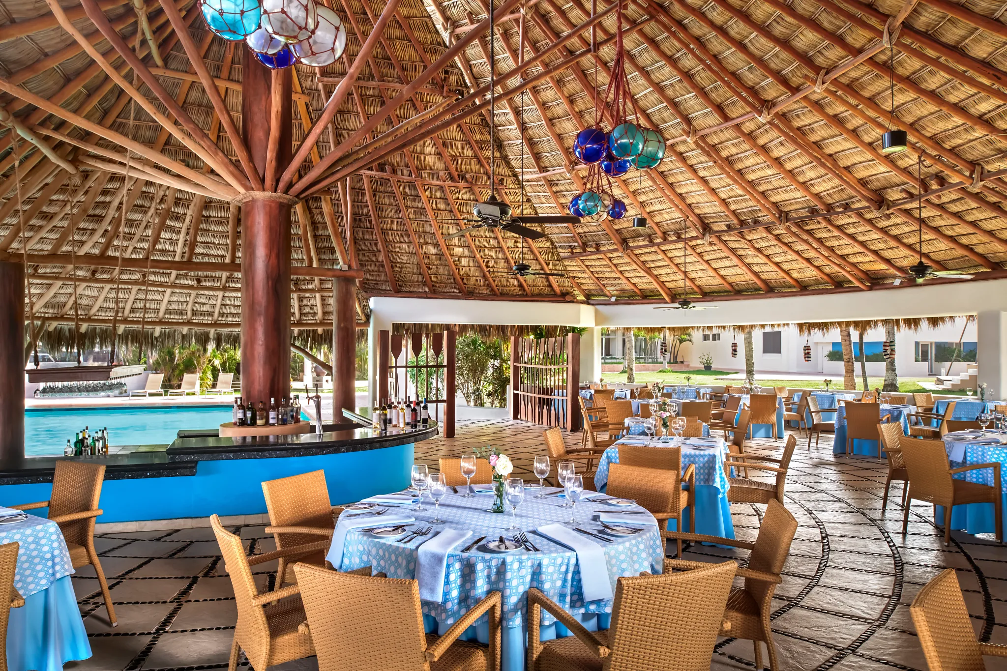 Bluewater Grill at Sunscape Dorado Pacifico Ixtapa featuring open-air palapa dining, blue table settings, and a poolside seaside ambiance.