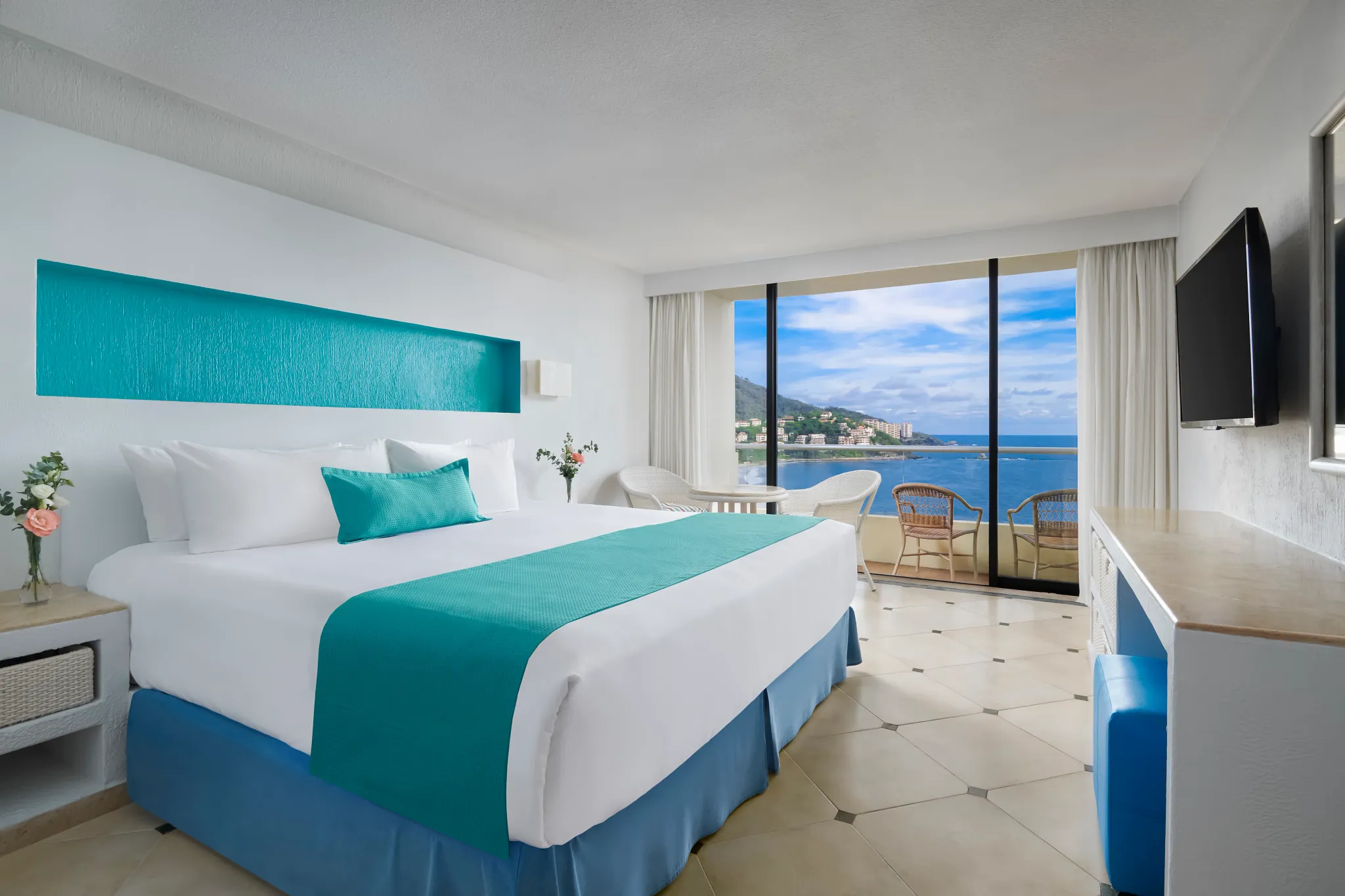 Deluxe Ocean View room with king bed and balcony overlooking Palmar Bay at Sunscape Dorado Pacifico Ixtapa.