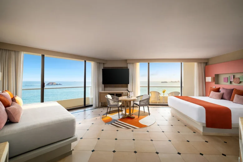 Sun Club Honeymoon Suite oceanfront living area with king bed, seating area, and panoramic Pacific views at Sunscape Dorado Pacifico Ixtapa.