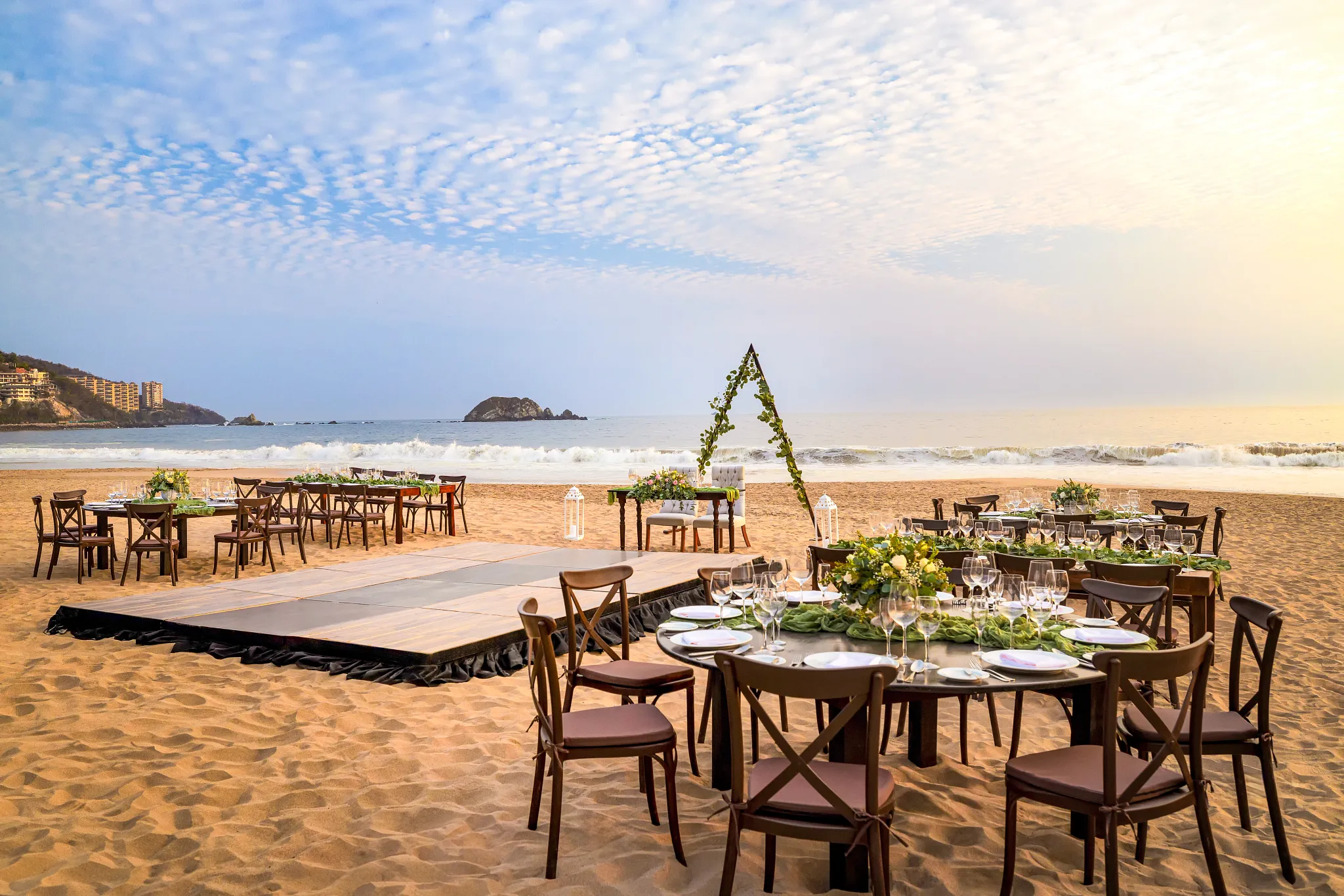 Beach wedding reception setup with wooden tables and ocean views at Sunscape Dorado Pacifico Ixtapa