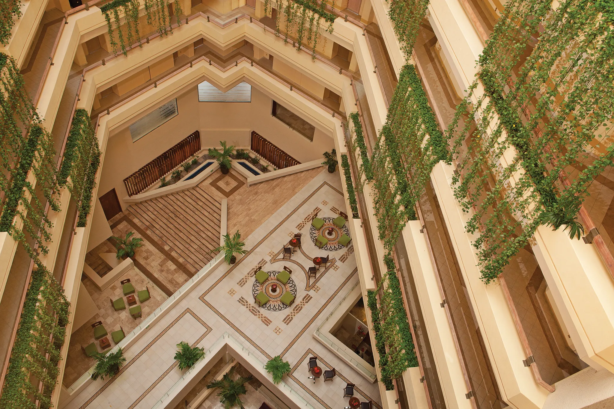 Multi-level interior atrium with balconies and tropical plants at Sunscape Dorado Pacifico Ixtapa.