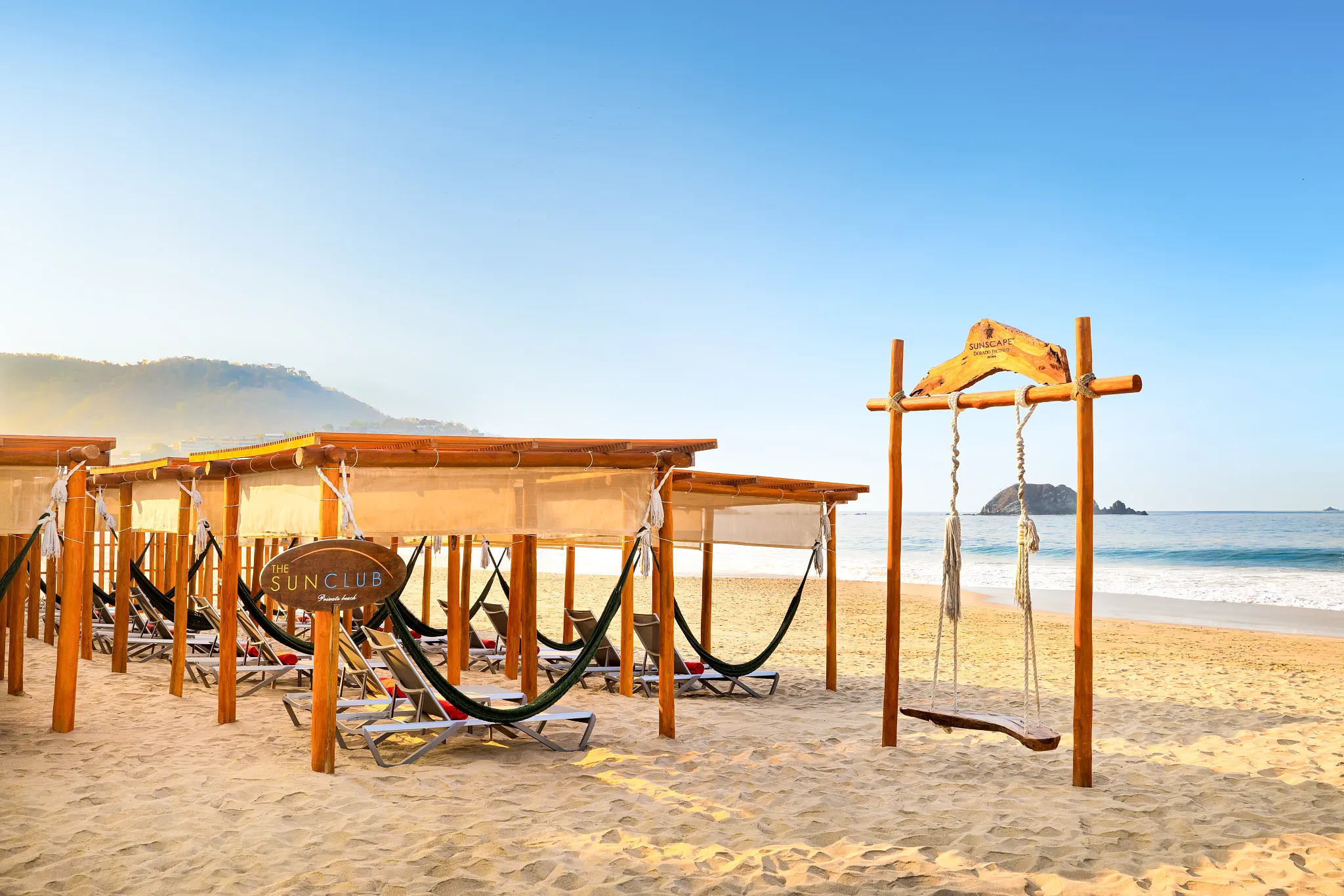 Sun Club beach area at Sunscape Dorado Pacifico Ixtapa featuring lounge chairs, hammocks, and ocean views.
