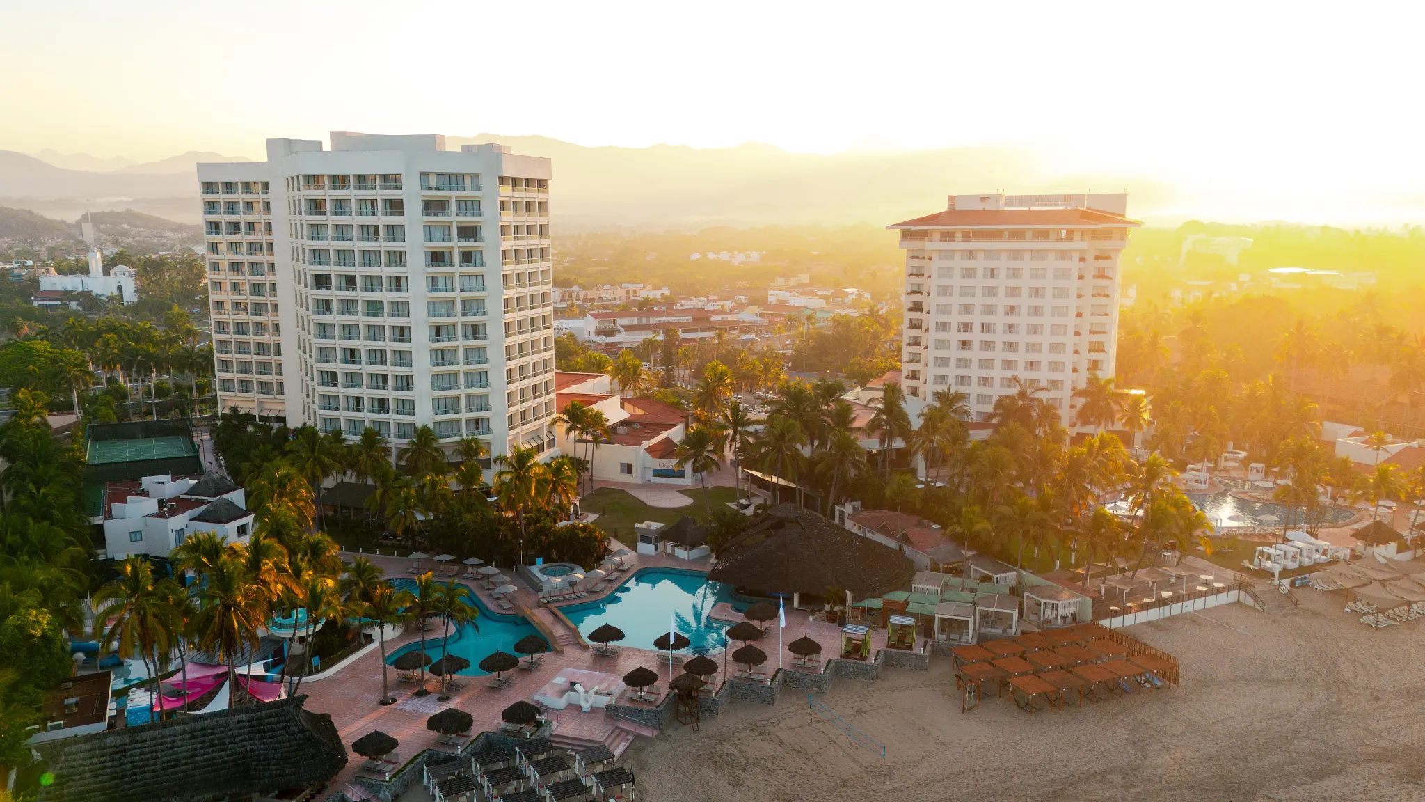 Sunset aerial view of Sunscape Dorado Pacifico Ixtapa with beachfront pools and tropical surroundings.