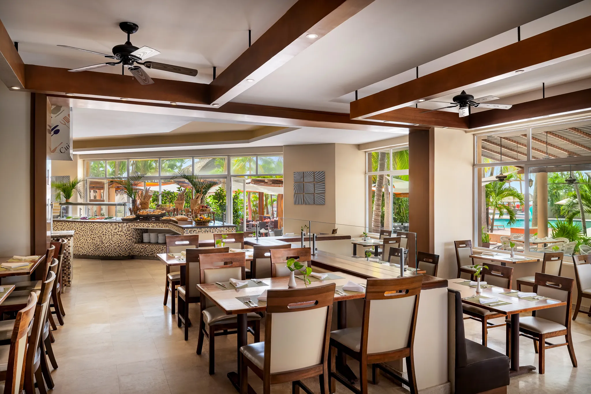 Windows International Buffet at Sunscape Dorado Pacifico Ixtapa featuring modern dining area, buffet stations, and poolside garden views.